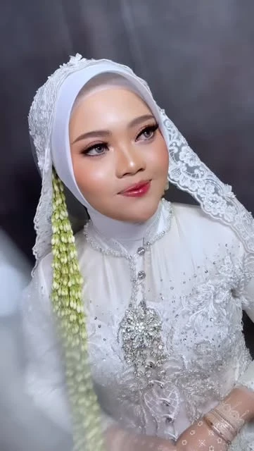 Detail rias pengantin berhijab putih dengan rangkaian melati