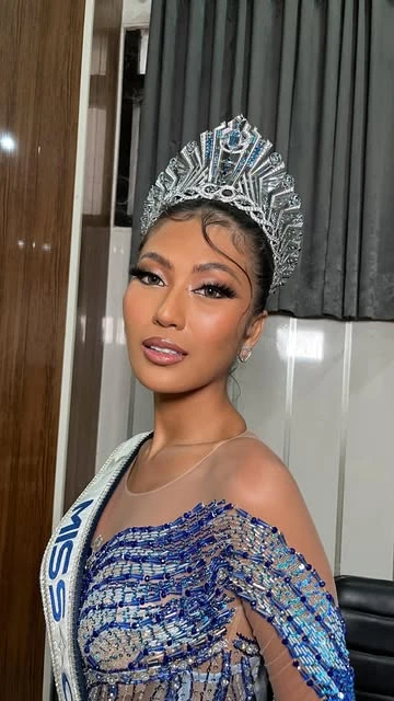 Detail makeup peserta pageant dengan mahkota perak dan gaun biru berhias manik