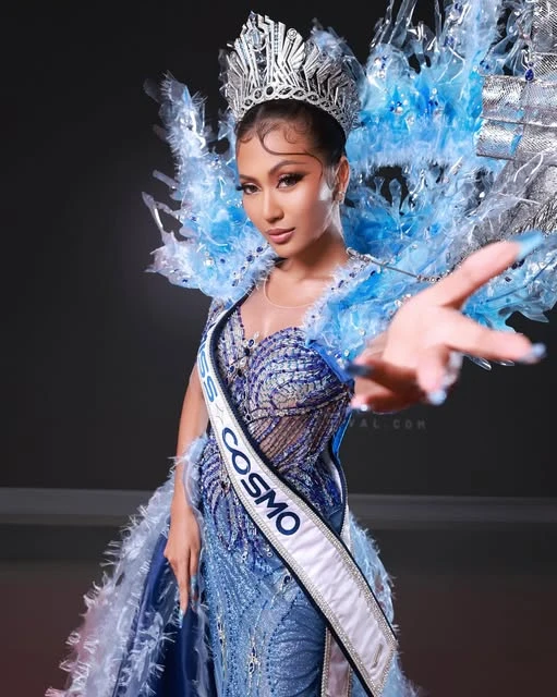 Potret pageant dengan mahkota perak, kostum biru kristal, dan rias mata tegas